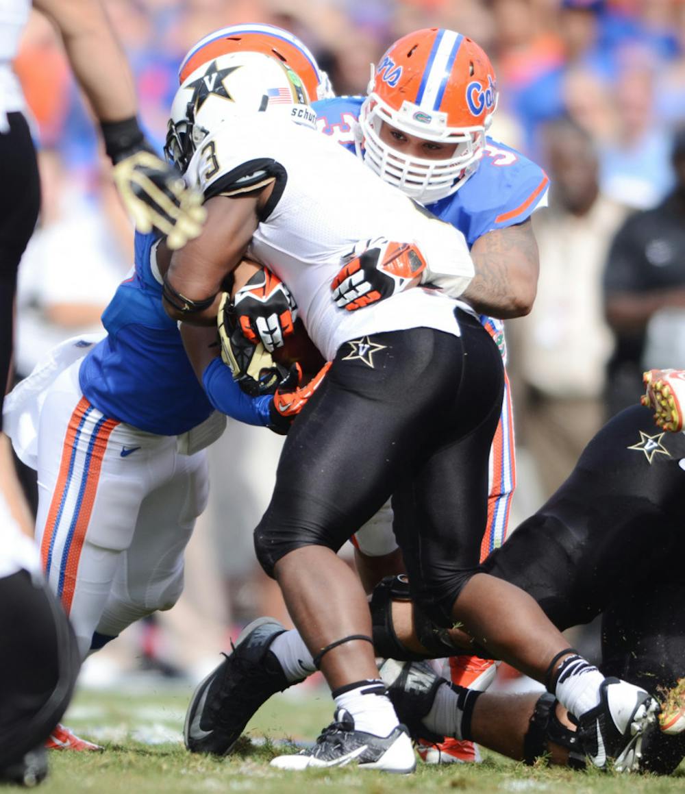 <p>Antonio Morrison helps tackle Vanderbilt running back Jerron Seymour during the Gators’ 34-17 loss to the Commodores in the 2013 season.</p>