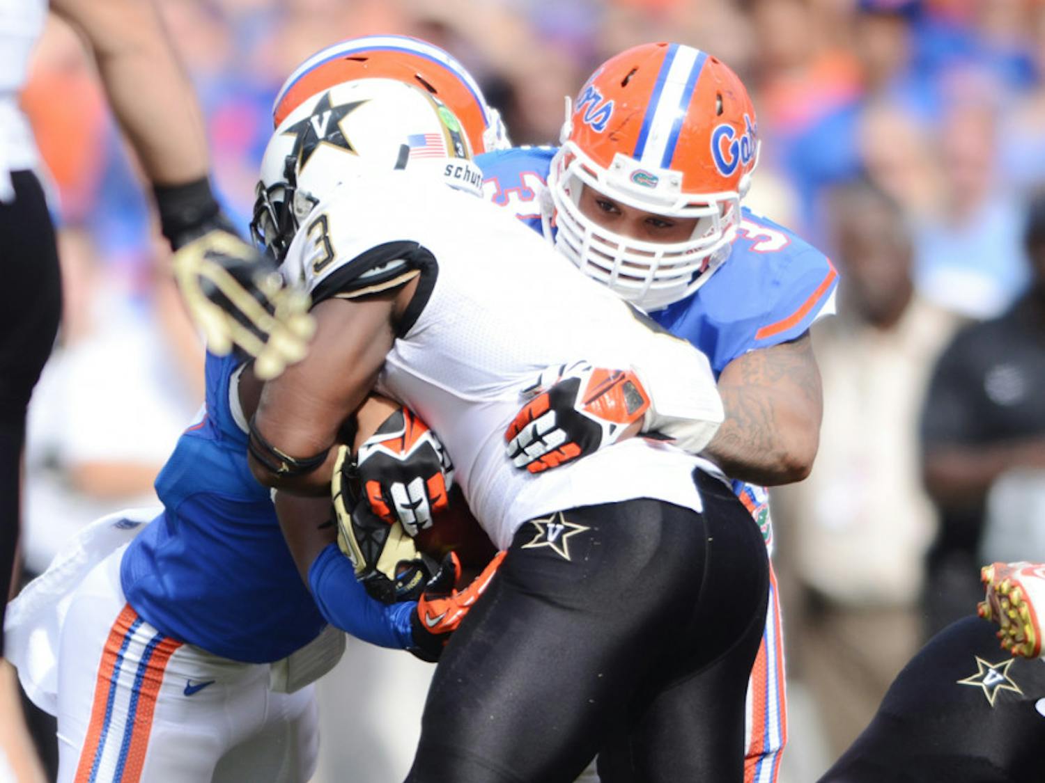 Antonio Morrison helps tackle Vanderbilt running back Jerron Seymour during the Gators’ 34-17 loss to the Commodores in the 2013 season.