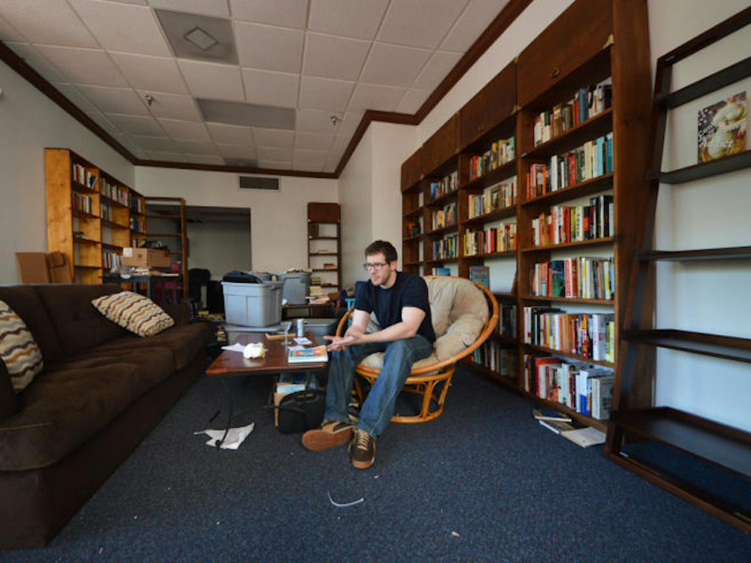 David Merahn, 26, works to prepare Broken Shelves bookstore for Friday’s soft opening. Merahn said he wants to create a place where creative and engaging minds can hang out and socialize.