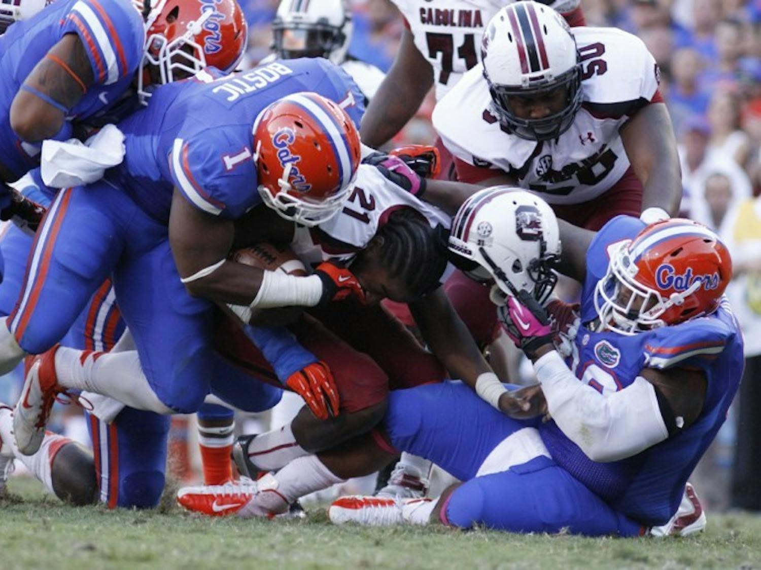 Defensive tackle Omar Hunter (right) rips off Marcus Lattimore’s helmet during Florida’s 44-11 win against South Carolina on Saturday at Ben Hill Griffin Stadium.&nbsp;