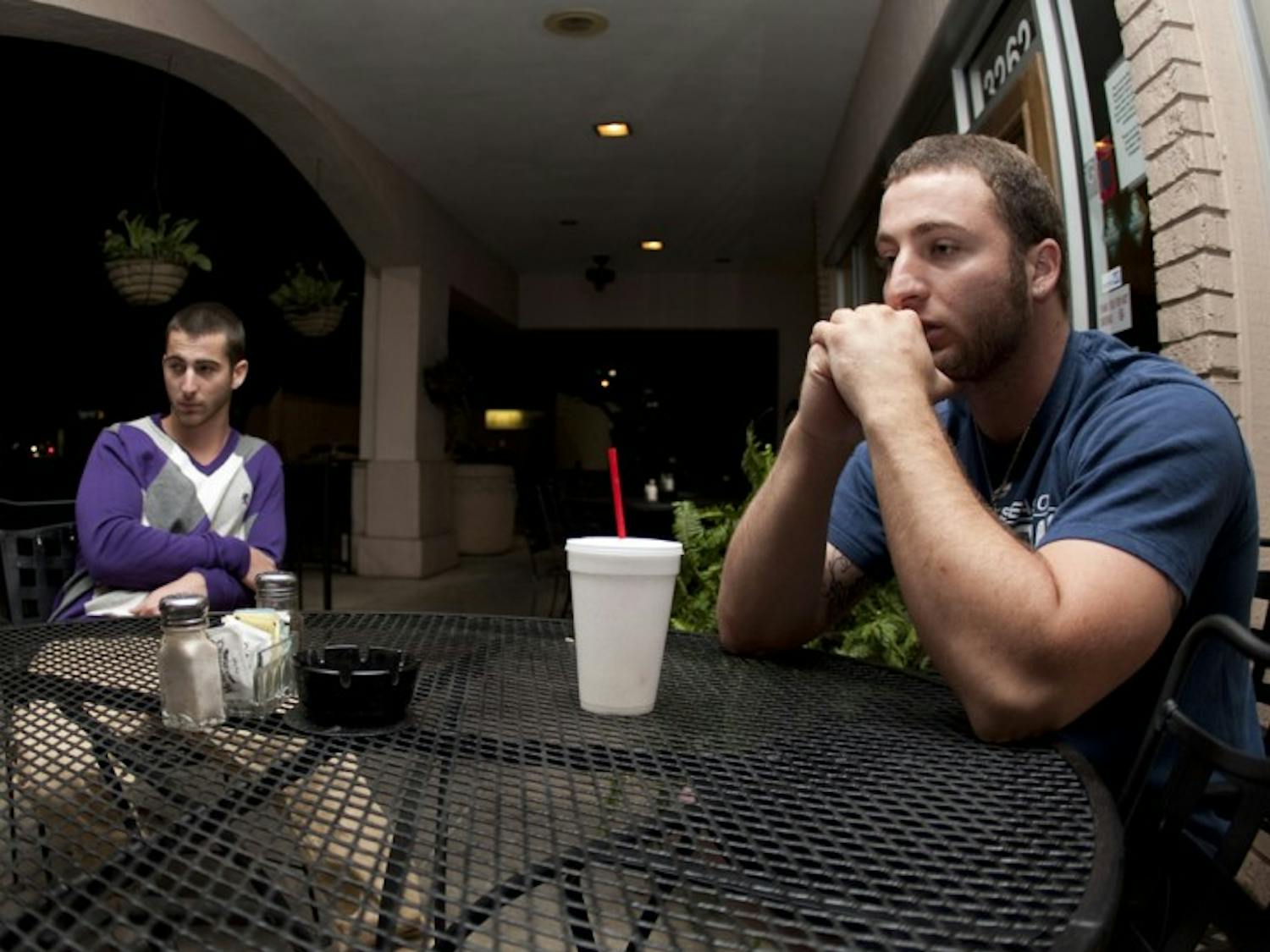 Jude Rizzo, 21, right, sits with his 19-year-old brother, Joel Rizzo, at McAlister’s Deli. Jude told police he shot and killed his roommate, Michael Crace, in self-defense on April 2.