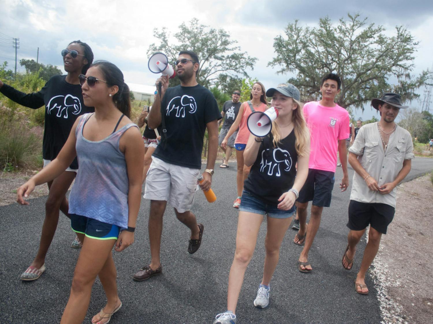 Students march for the rights of elephants and rhinos in Asia at Depot Park on Sunday afternoon.