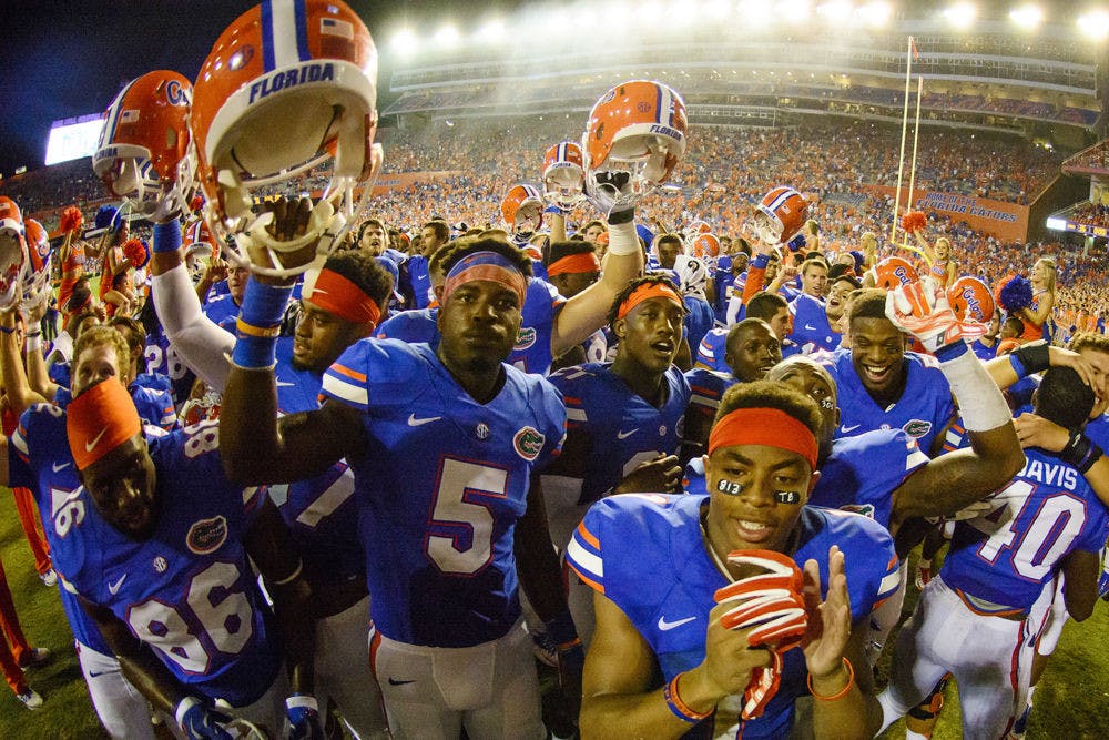 <p>UF football players celebrate following Florida's 36-30 triple-overtime win against Kentucky on Sept. 13 at Ben Hill Griffin Stadium.</p>