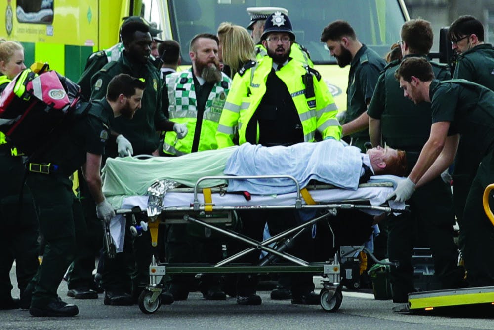 Emergency services staff provide medical attention to injured people on the south side of Westminster Bridge, close to the Houses of Parliament in London, Wednesday, March 22, 2017. London police say they are treating a gun and knife incident at Britain's Parliament "as a terrorist incident until we know otherwise." The Metropolitan Police says in a statement that the incident is ongoing. Officials say a man with a knife attacked a police officer at Parliament and was shot by officers. Nearby, witnesses say a vehicle struck several people on the Westminster Bridge. 