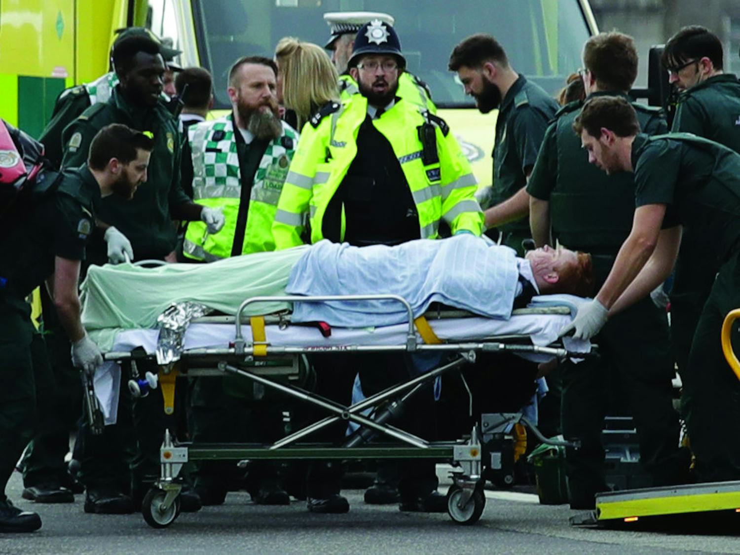 Emergency services staff provide medical attention to injured people on the south side of Westminster Bridge, close to the Houses of Parliament in London, Wednesday, March 22, 2017. London police say they are treating a gun and knife incident at Britain's Parliament "as a terrorist incident until we know otherwise." The Metropolitan Police says in a statement that the incident is ongoing. Officials say a man with a knife attacked a police officer at Parliament and was shot by officers. Nearby, witnesses say a vehicle struck several people on the Westminster Bridge.