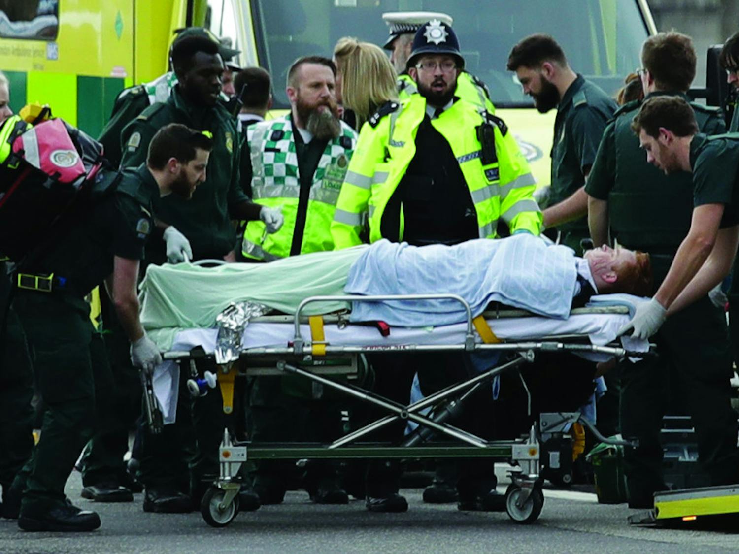 Emergency services staff provide medical attention to injured people on the south side of Westminster Bridge, close to the Houses of Parliament in London, Wednesday, March 22, 2017. London police say they are treating a gun and knife incident at Britain's Parliament "as a terrorist incident until we know otherwise." The Metropolitan Police says in a statement that the incident is ongoing. Officials say a man with a knife attacked a police officer at Parliament and was shot by officers. Nearby, witnesses say a vehicle struck several people on the Westminster Bridge. 