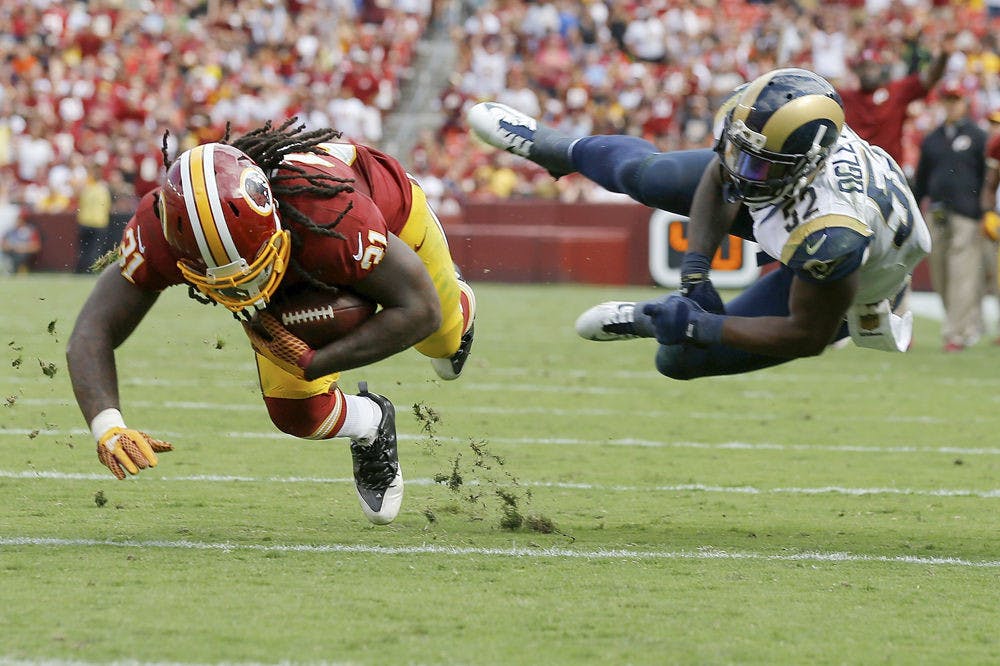 In this photo taken Sept. 20, 2015, Washington Redskins running back Matt Jones (31) dives for extra yardage after breaking a tackle by St. Louis Rams outside linebacker Alec Ogletree (52) during the second half of an NFL football game in Landover, Md.