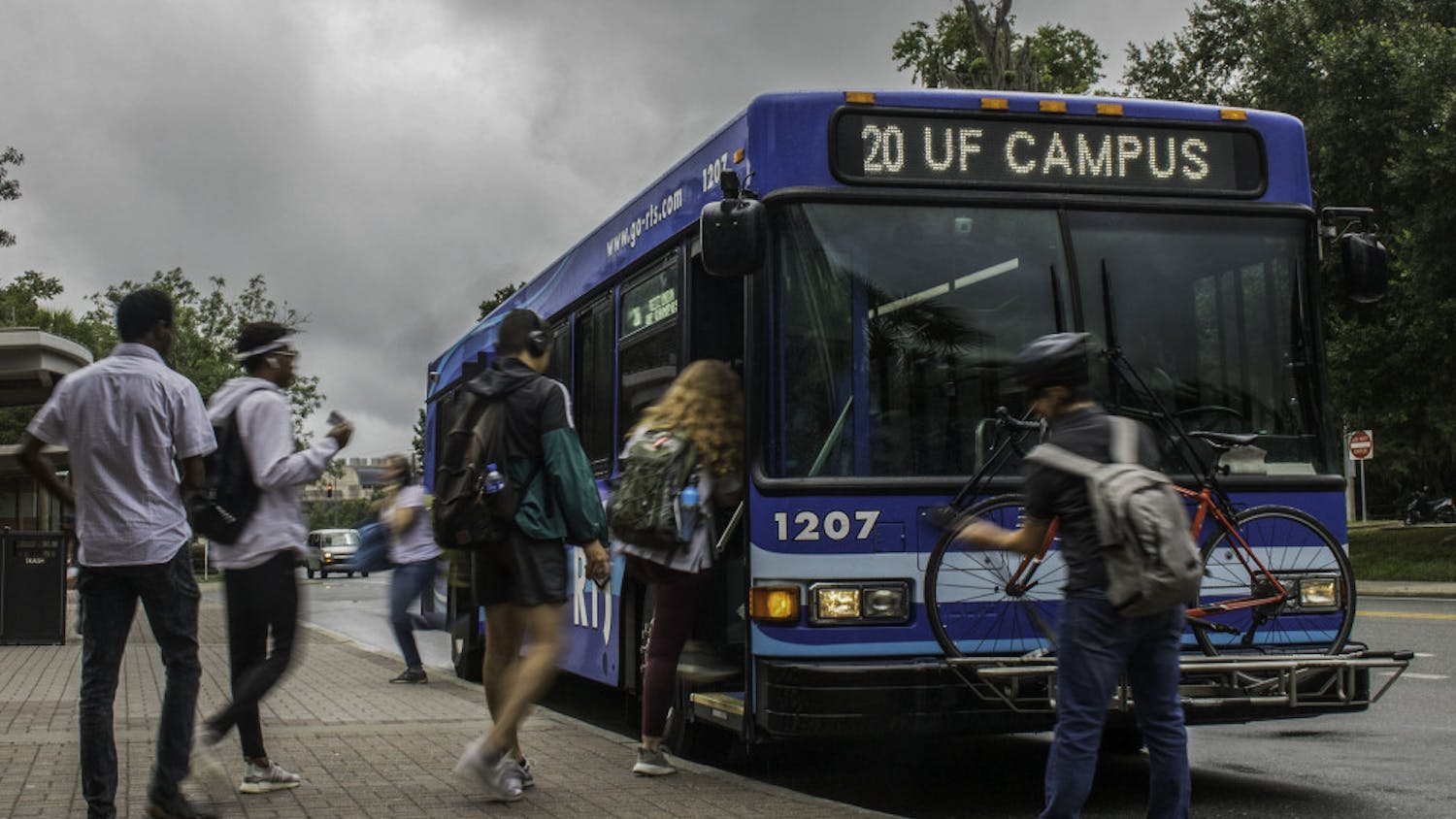 People board and exit an RTS bus Wednesday, July 24, 2019 by the The Hub at UF.