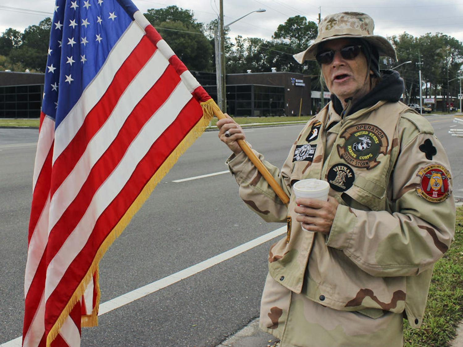 Cody Anderson, a member of the Military Support Group of Alachua County, holds a flag during the protest against Clock Restaurant on Saturday morning. “I felt it was important to support Mr. Woods,” Anderson said. “I felt that the way he was treated was not only illegal but immoral.”