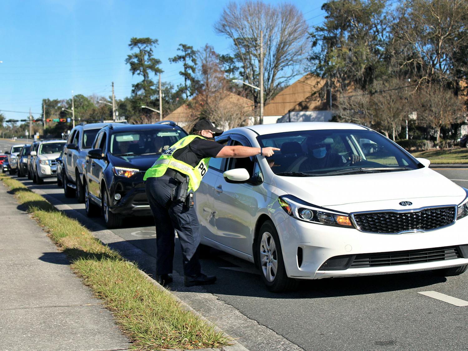 J. Evans, a Gainesville Police Department officer, directs traffic into Malcom Randall VA Medical Center on Monday, Jan. 18, 2021. A long line of traffic formed outside the hospital as Alachua County residents 65-years-old and older waited to receive COVID-19 vaccines.