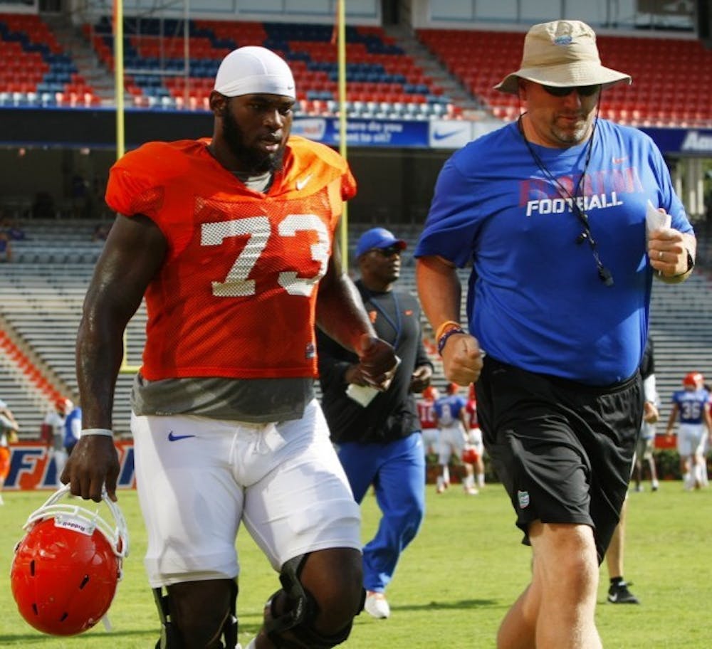 <p>Defensive Tackle Sharrif Floyd runs off the field with Strength and Conditioning Coach Jeff Dillman, Aug. 18 at Ben Hill Griffin Stadium</p>