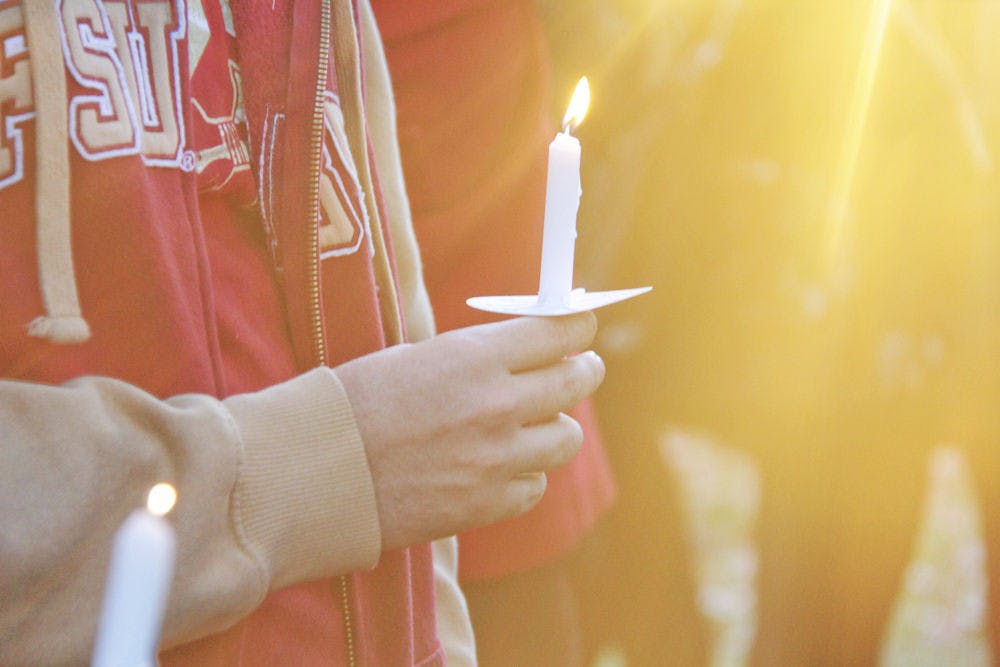 <p>FSU students stand together at the Integration Statue Gathering of Unity on Thursday evening, holding lit candles to honor their classmates who were injured in the shooting that took place at Strozier Library early that morning.</p>