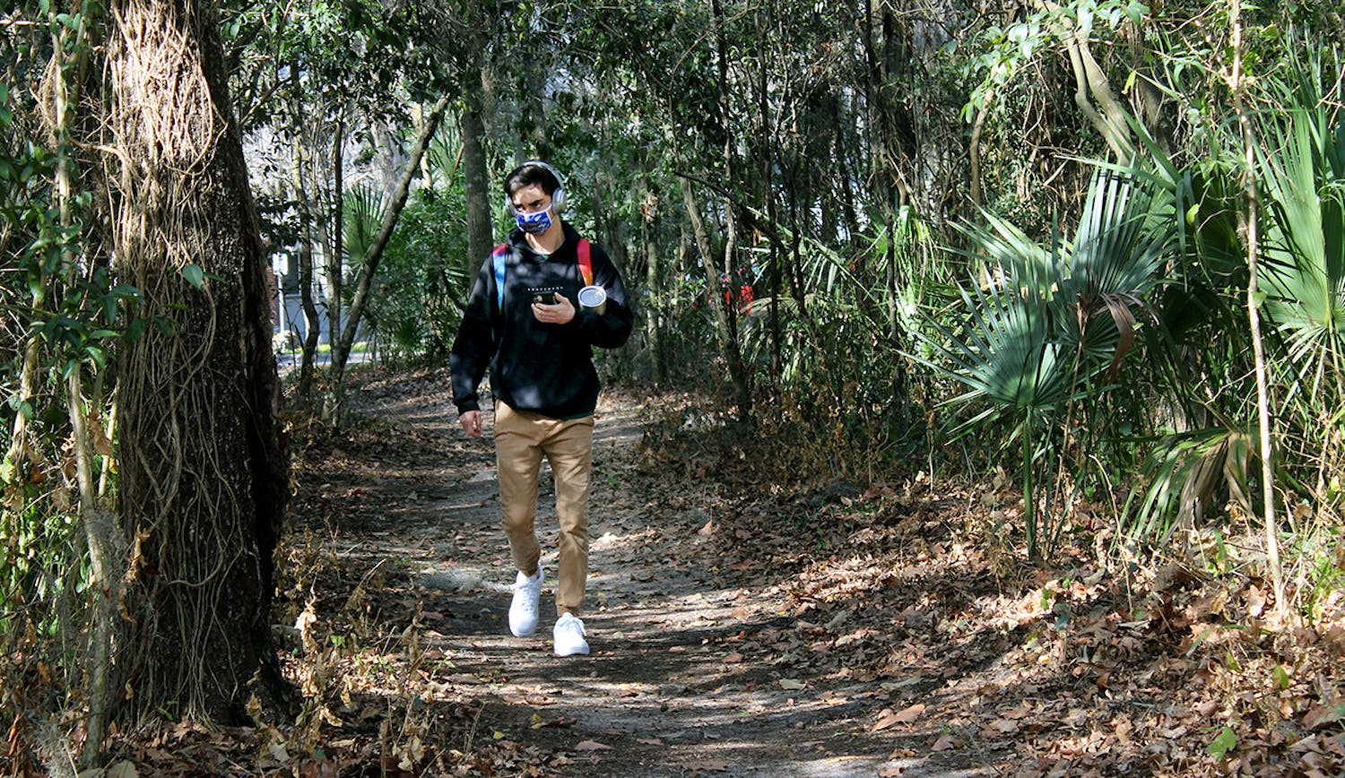 Matt Raulerson, 20, a forest resources and conservation junior, walks on a path through the McCarty Woods Conservation Area on Thursday, Feb. 4, 2021. Raulerson expressed disappointment at the news that the conservation area has been approved as a possible future site for construction. "It's horrible," he said. "It would take away all the beauty of it. It's something I pass everyday I walk to class and it's something I love looking at." 