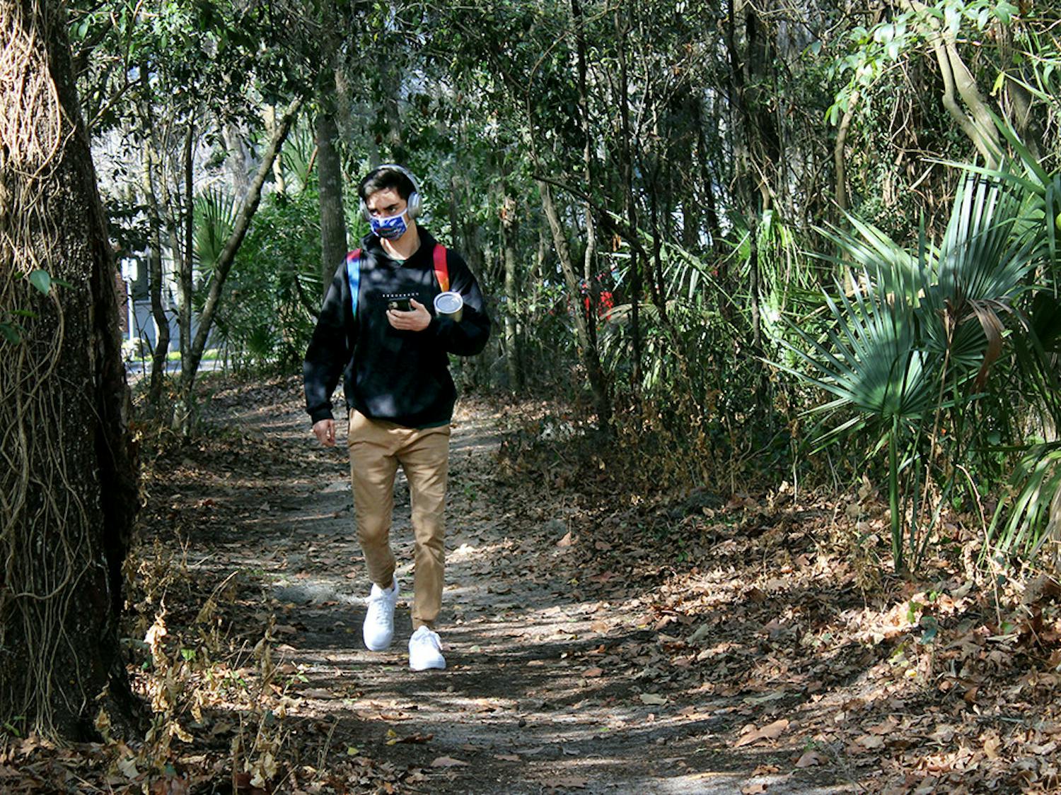 Matt Raulerson, 20, a forest resources and conservation junior, walks on a path through the McCarty Woods Conservation Area on Thursday, Feb. 4, 2021. Raulerson expressed disappointment at the news that the conservation area has been approved as a possible future site for construction. "It's horrible," he said. "It would take away all the beauty of it. It's something I pass everyday I walk to class and it's something I love looking at."