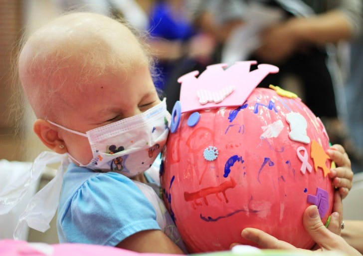 Madison, a 4-year-old undergoing treatment for leukemia at Shands Hospital for Children at UF, holds her pink pumpkin on Wednesday morning as part of an event for patients and families.