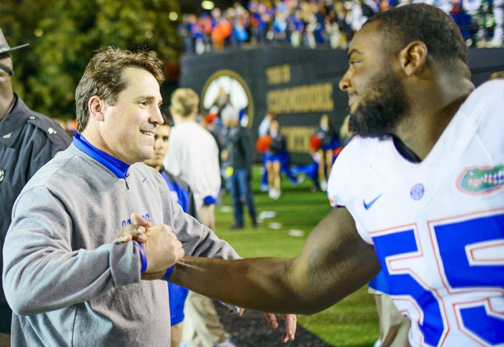 <p>Florida head coach Will Muschamp celebrates with defensive lineman Darious Cummings (55) following Gators' 34-10 win against Commodores on Saturday in Nashville, Tennessee.</p>