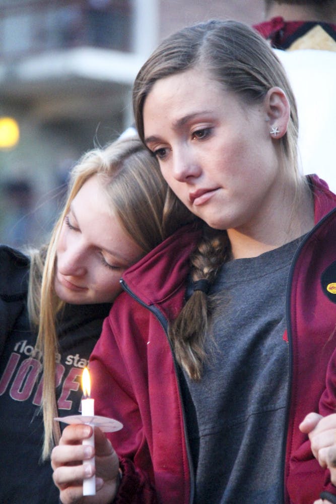 19-year-old FSU statistics freshman Olivia Heartsell, (left), leans on her teammate Amber Milner, a 22-year-old psychology junior, during the Gathering of Unity at the university’s Integration Statue on Thursday evening.