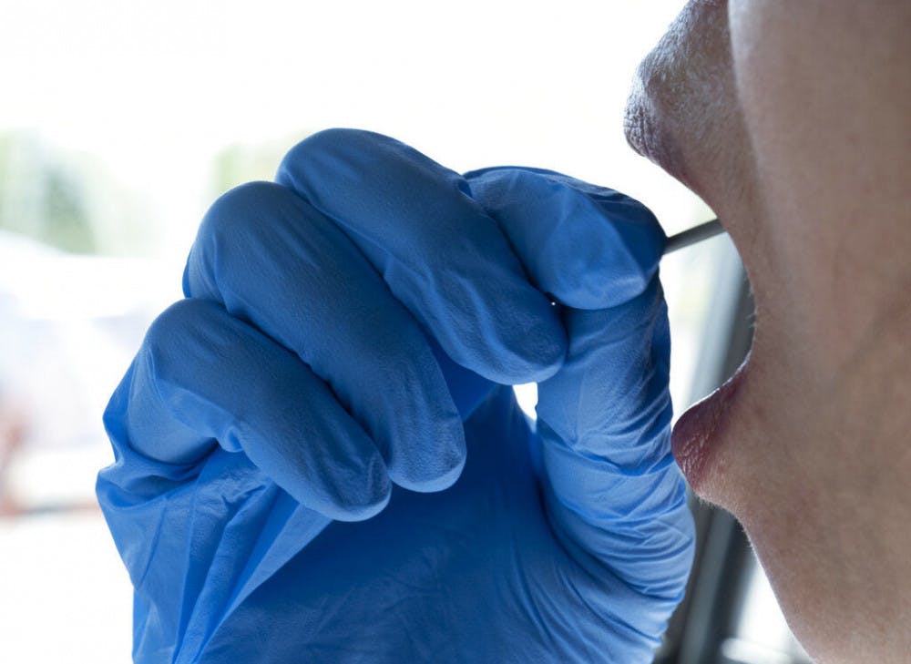 <p>In this Wednesday, May 6, 2020 photo a woman swabs the inside of her mouth during a self administered coronavirus test at a drive through testing site in a parking lot in the Woodland Hills section of Los Angeles. The city of Los Angeles is providing free coronavirus tests to anyone who wants one regardless of whether they have symptoms. The offer reflects a parting with state guidelines after the mayor partnered with a startup testing company. The test the city is offering is easier to administer and doesn't require the scarce supplies that have created bottlenecks for expanded testing across California. (AP Photo/Richard Vogel)</p>