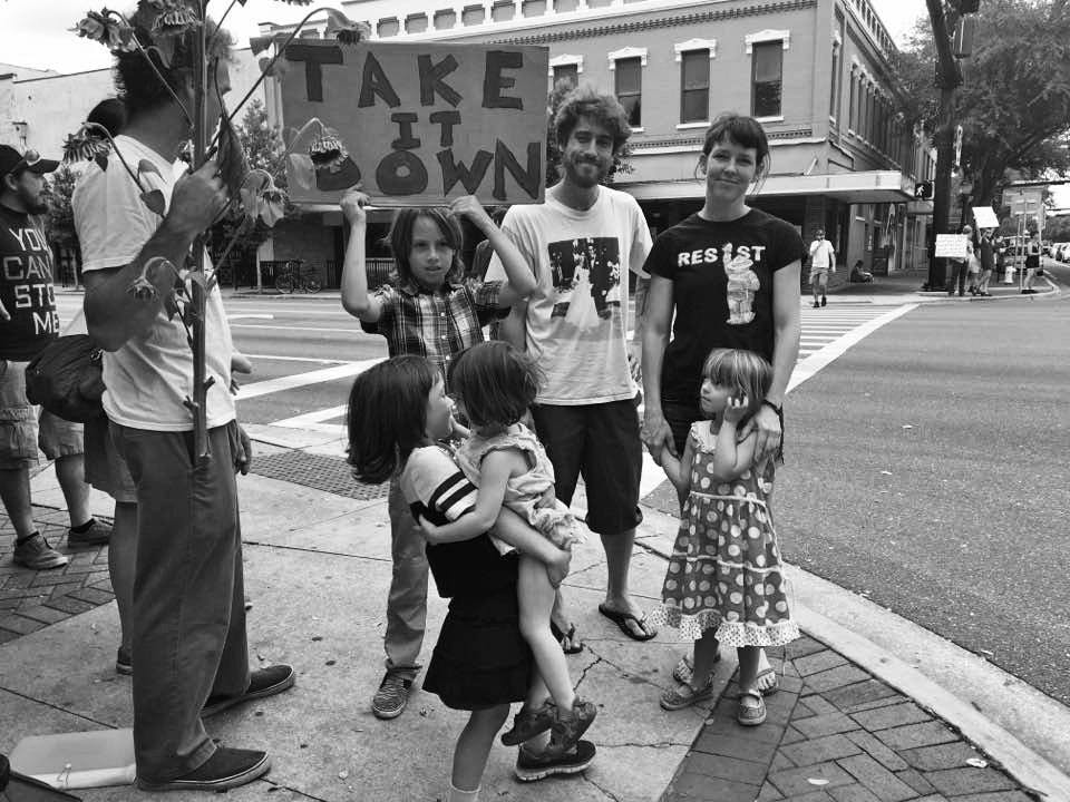 Protesters young and old stand at the corner of Southeast University Avenue and Main Street in opposition to the “Old Joe” Confederate soldier statue. Demonstrators shouted through megaphones across all four corners of the intersection chants such as “Old Joe has got to go” and “No hate. No KKK. No fascist USA.”