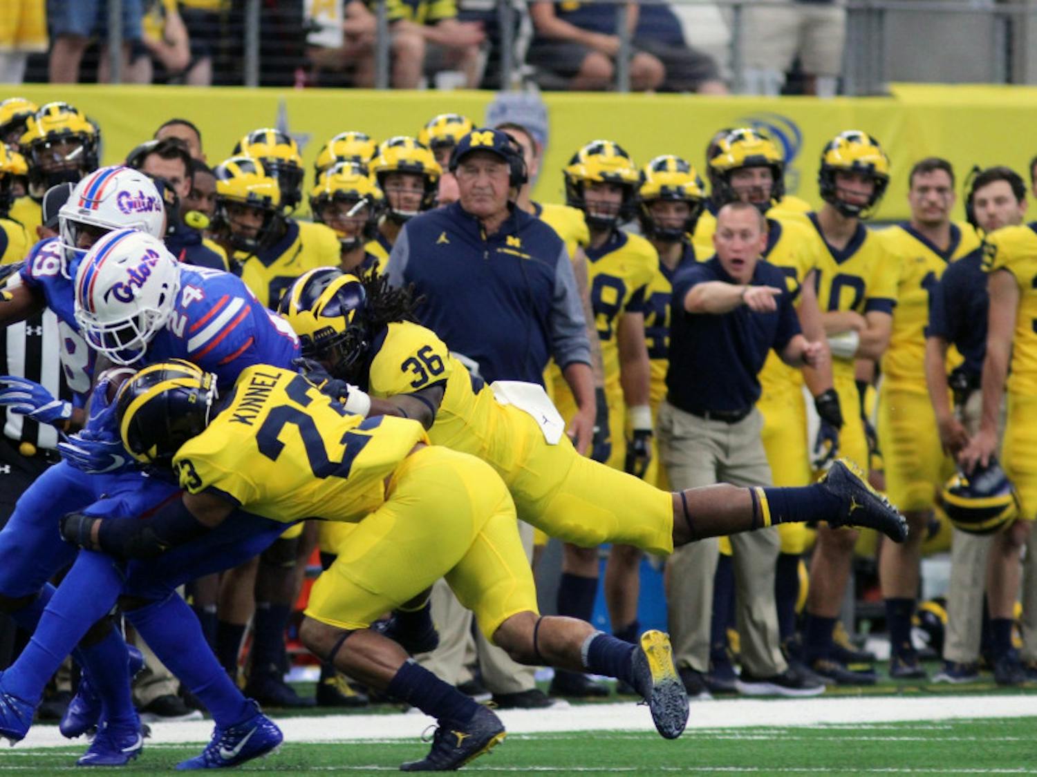 UF running back Mark Thompson (24) gets tackled while running with the ball in Florida's 33-17 loss to Michigan on Saturday in AT&T Stadium in Arlington, Texas.