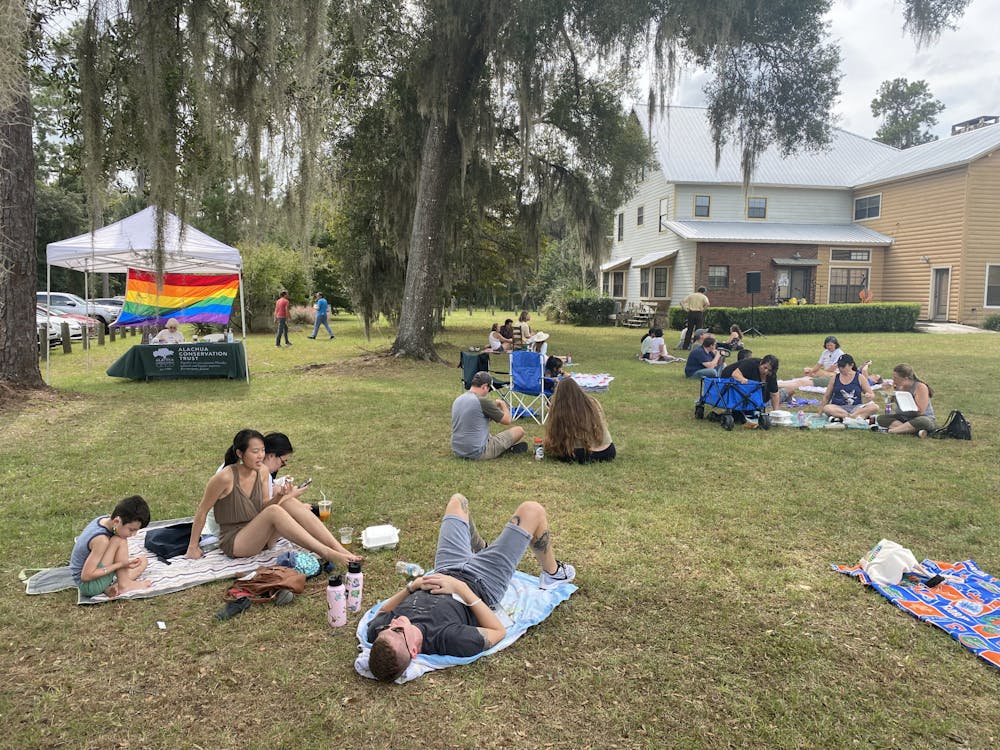 <p>Attendees lounge on the grounds of the Prairie Creek Lodge at the Pride at Prairie Creek event Oct. 24. </p>