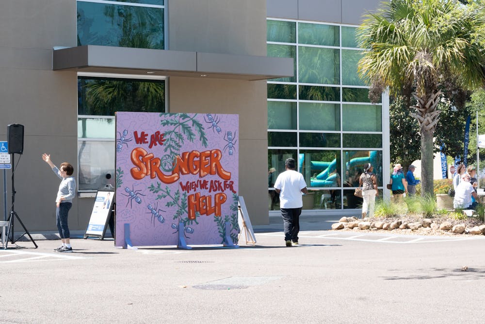 Attendees walk past art displayed at Santa Fe College for the Spring Arts Festival on Sunday, April 14, 2024.