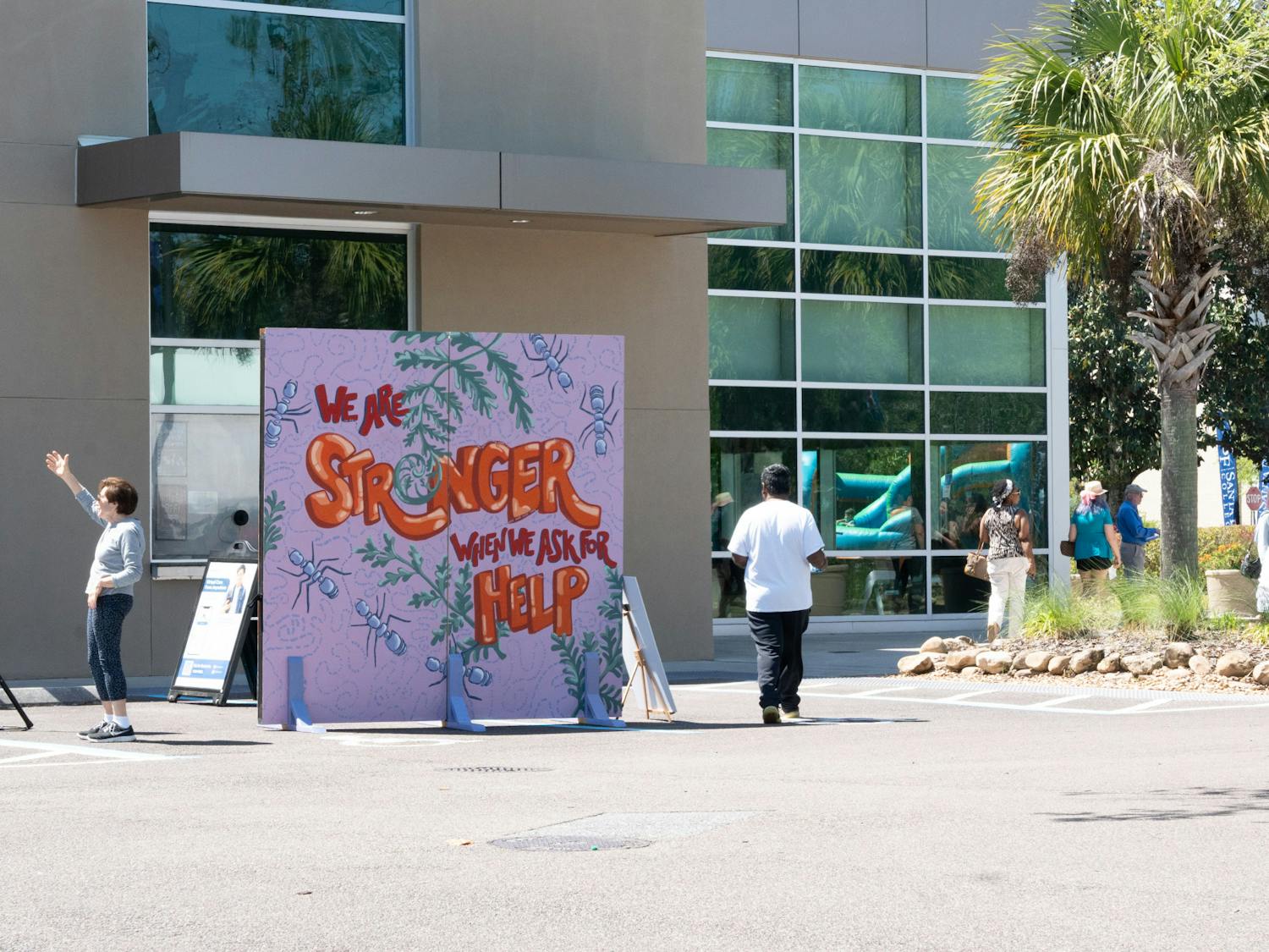 Attendees walk past art displayed at Santa Fe College for the Spring Arts Festival on Sunday, April 14, 2024.