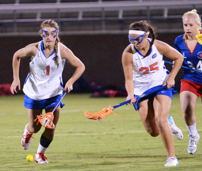Freshman Lauren Lea (1) chases the ball with teammate Gabi Wiegand (35) during Florida’s 18-13 exhibition win against England on Thursday night at Dizney Stadium.