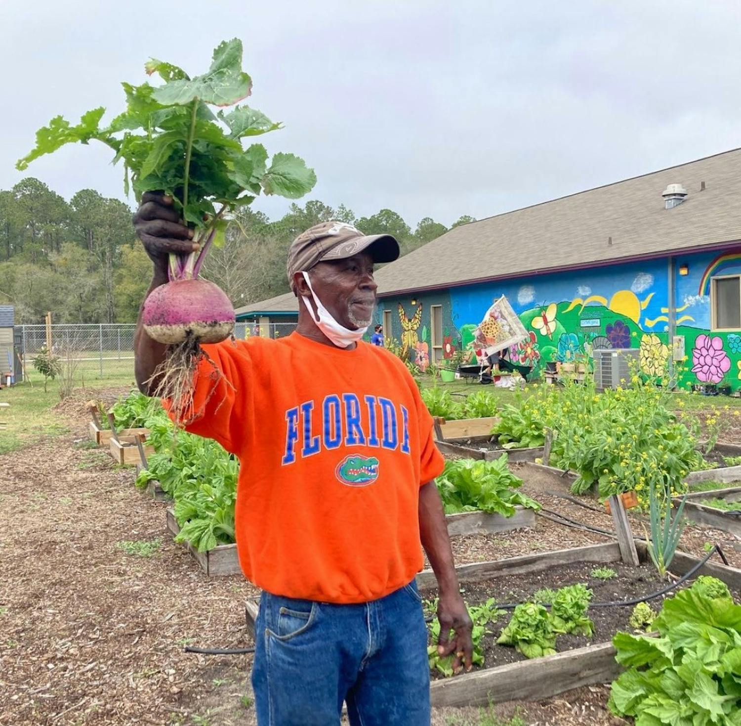 Joseph Scott, 60, stands next to his personal garden at GRACE Marketplace. [Photo courtesy to the Alligator]