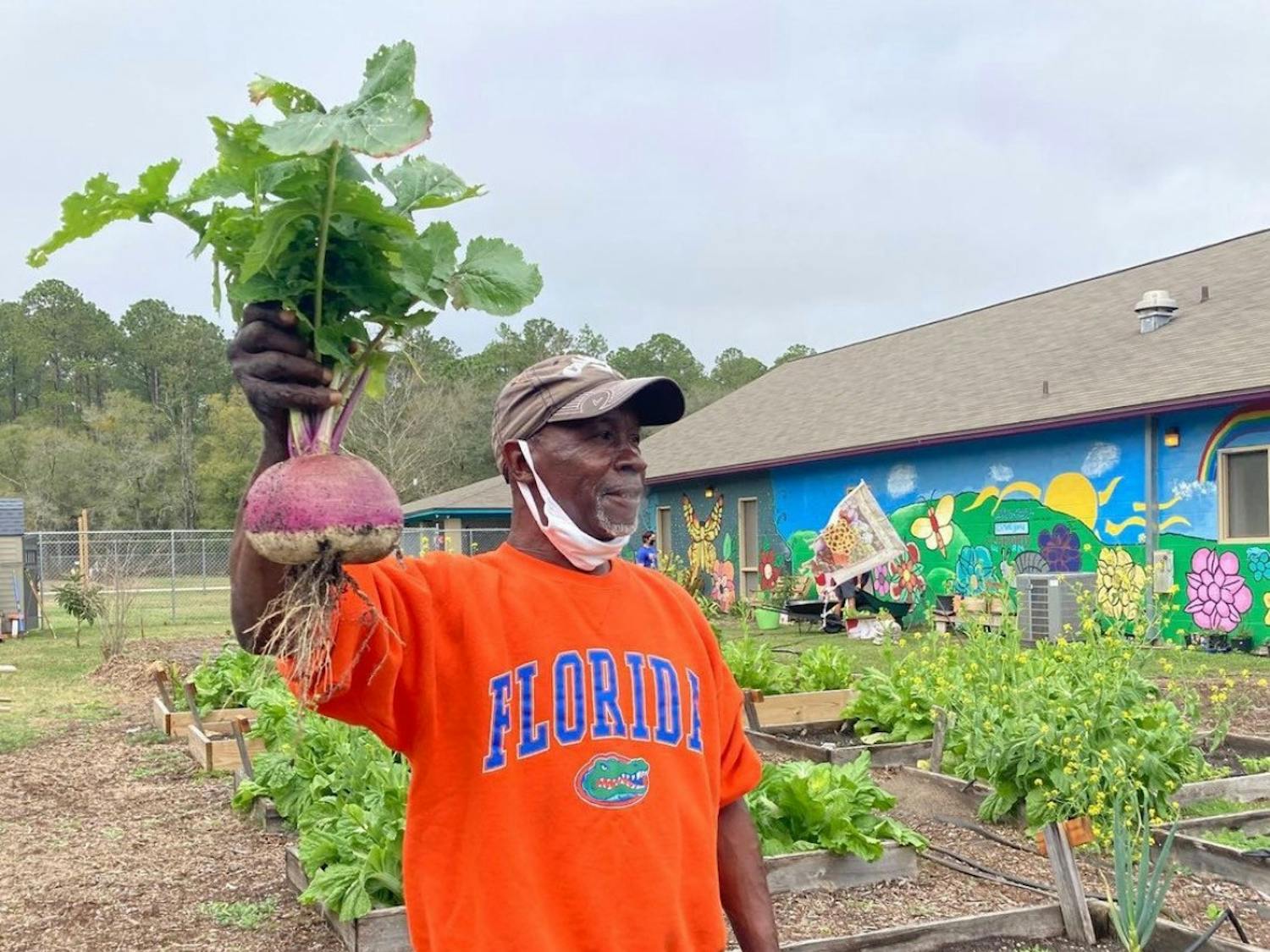 Joseph Scott, 60, stands next to his personal garden at GRACE Marketplace. [Photo courtesy to the Alligator]