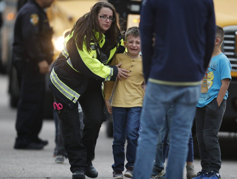 Officials guide students off a bus and into a recreation center where they were reunited with their parents after a shooting at a suburban Denver middle school Tuesday, May 7, 2019, in Highlands Ranch, Colo.