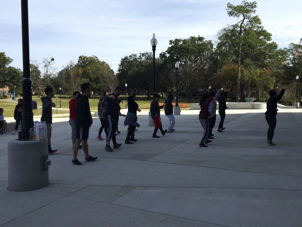 Students learn to dance a Bhangra routine outside the Reitz Union on Saturday morning. The Asian American Student Union hosted the Pop It to the Polls event to encourage students to register while learning how to dance.