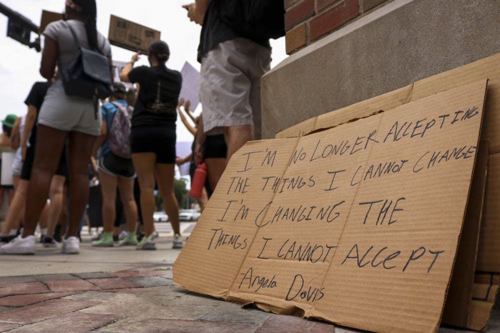Extra signs left by protestors Wednesday as the crowd chants and waves to passing cars at the intersection of 13th Street and University Avenue during a protest against police brutality.&nbsp;
&nbsp;