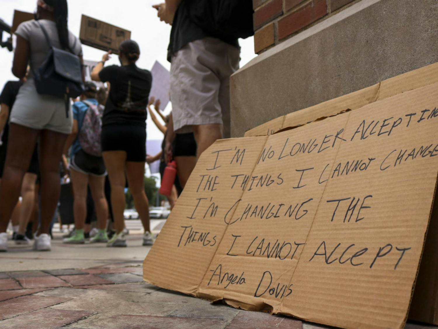 Extra signs left by protestors Wednesday as the crowd chants and waves to passing cars at the intersection of 13th Street and University Avenue during a protest against police brutality.
