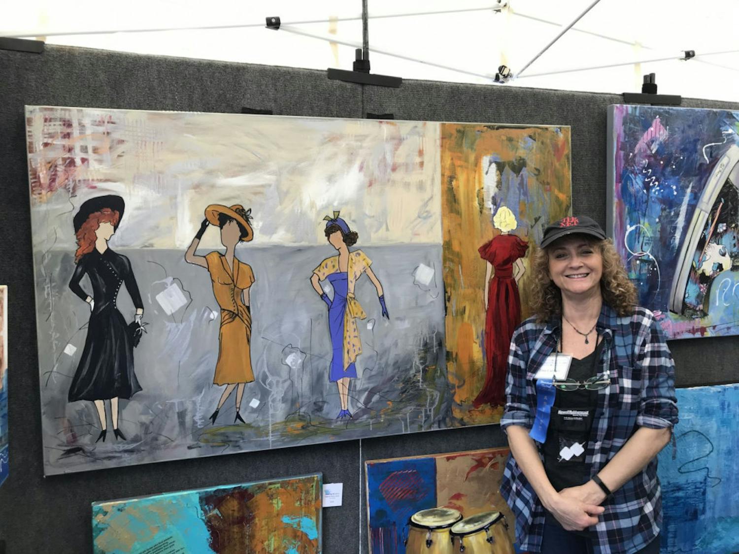 Tina Corbett, artist and owner of Lanza Gallery &amp; Art Supplies, works her art booth at the 37th Annual Downtown Festival &amp; Art Show Sunday. The painting is called “Me Too.”
&nbsp;
