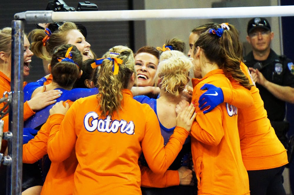 <p>Bridget Sloan celebrates with teammates after scoring a perfect 10.0 on bars during Florida's win against Texas Woman's University on March 13 in the O'Connell Center.</p>