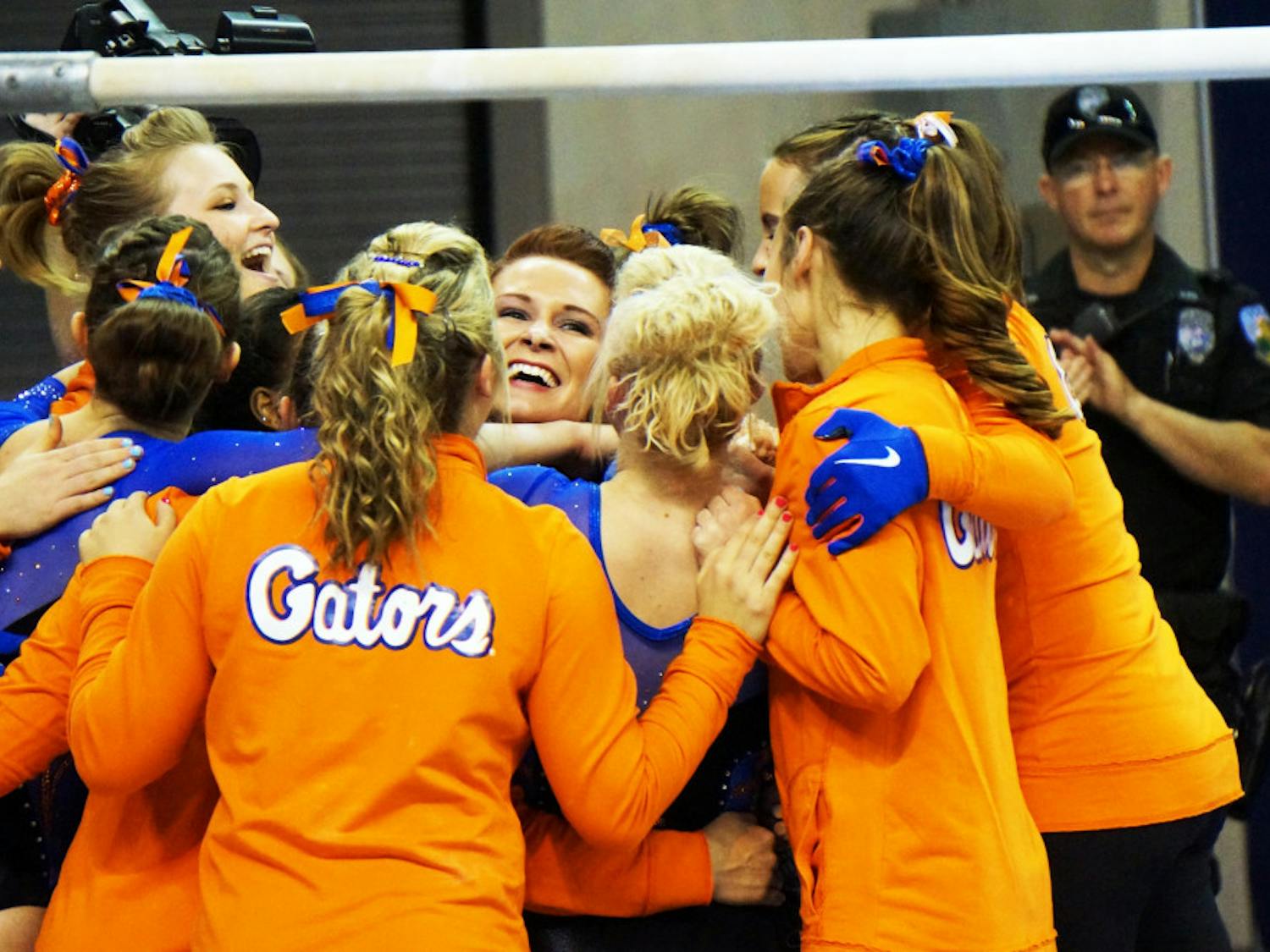 Bridget Sloan celebrates with teammates after scoring a perfect 10.0 on bars during Florida's win against Texas Woman's University on March 13 in the O'Connell Center.