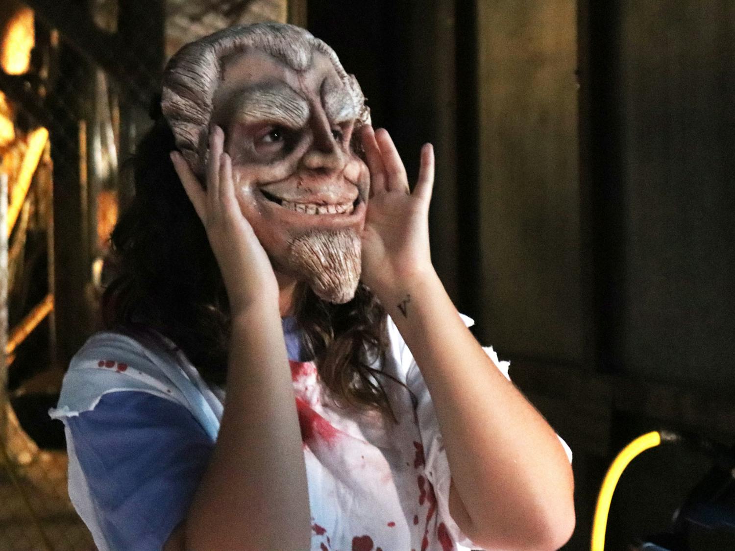 Vanessa Garcia adjusts her mask to scare participants at the Gainesville Fear Garden on Sunday, Oct. 1, 2023.