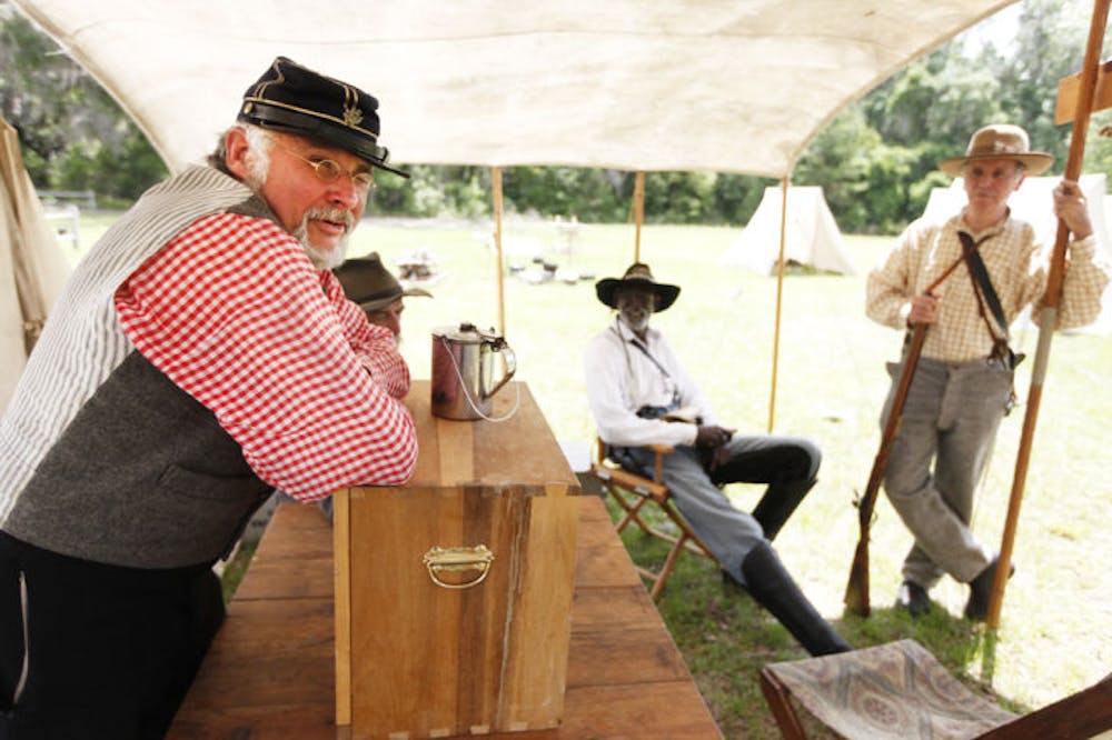 <p>Maj. Thomas Sanders takes a break with fellow Civil War re-enactors at the 7th Florida Infantry Regiment Muster at Dudley Farm Historic State Park on Friday morning.</p>