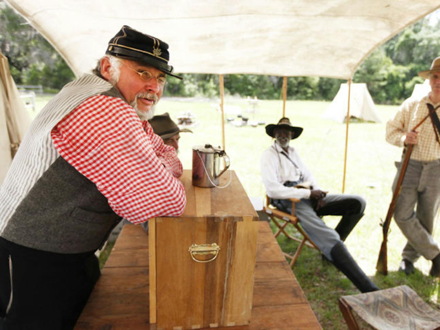 Maj. Thomas Sanders takes a break with fellow Civil War re-enactors at the 7th Florida Infantry Regiment Muster at Dudley Farm Historic State Park on Friday morning.
