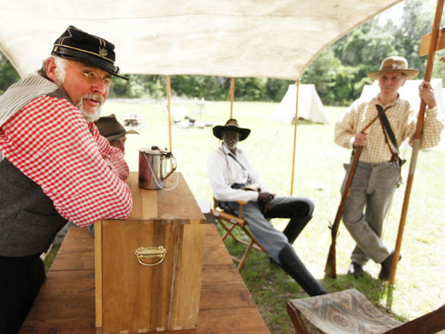 Maj. Thomas Sanders takes a break with fellow Civil War re-enactors at the 7th Florida Infantry Regiment Muster at Dudley Farm Historic State Park on Friday morning.