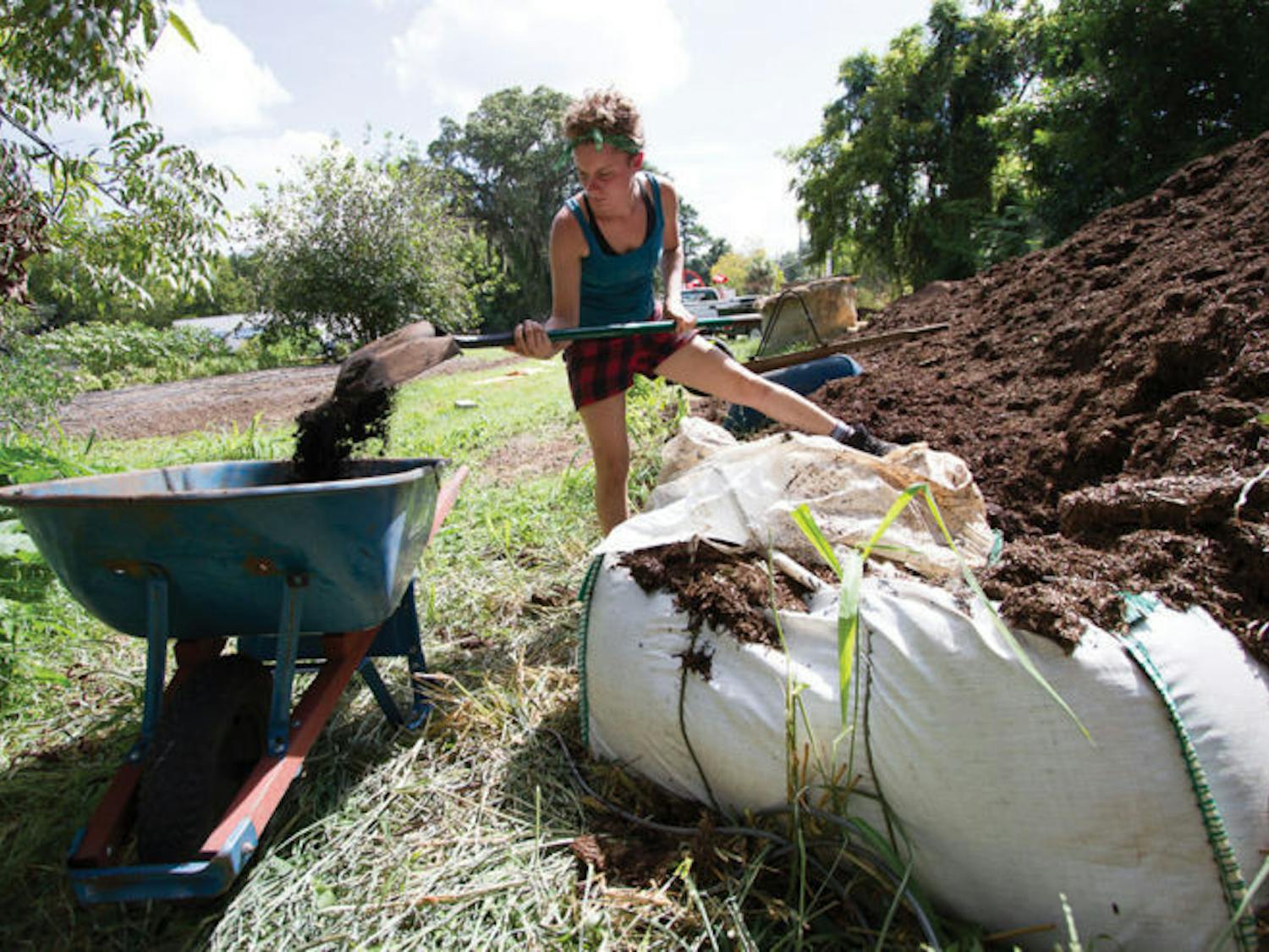 Ellen Vessels, 27, coordinator of the Florida Organic Growers GIFT Gardens program, shovels compost at Porters Community Garden, located at 518 SW Third St.
