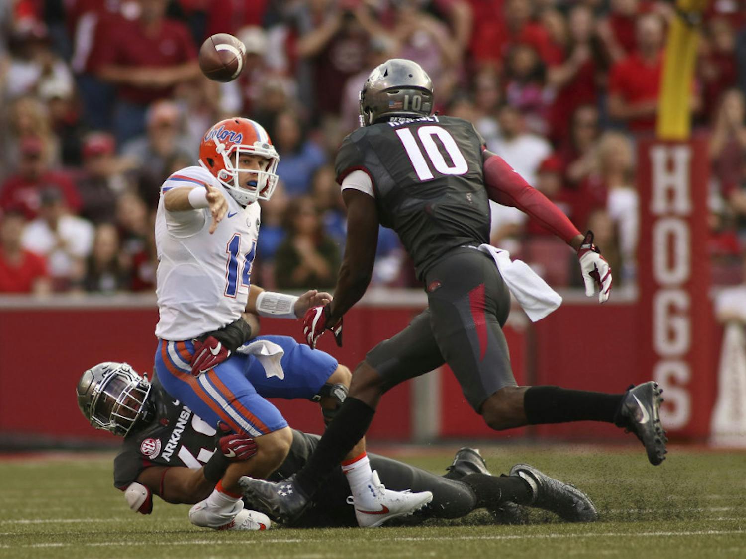 Florida's Luke Del Rio (14) looses the ball before being taken down by Arkansas' Deatrich Wise Jr. (48) and Randy Ramsey (10) during the second half of an NCAA college football game on Nov. 5, 2016 in Fayetteville, Arkansas. Arkansas beat Florida 31-10. (AP Photo/Samantha Baker)