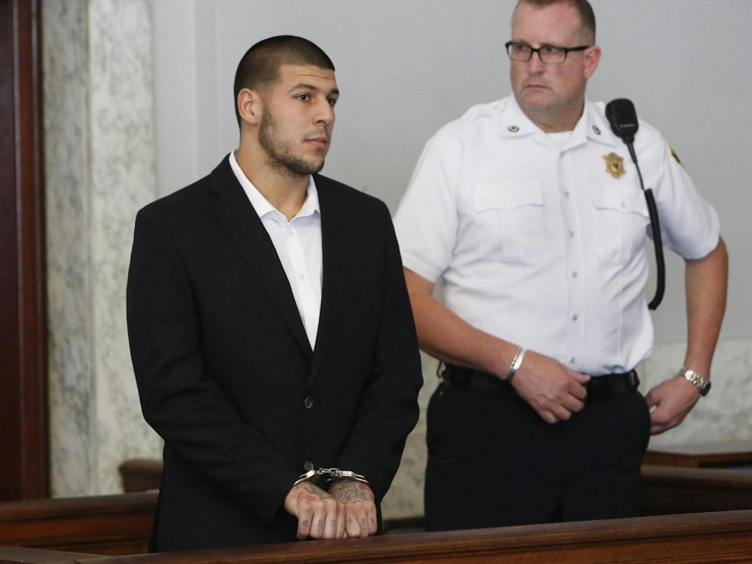 Aaron Hernandez, left, appears at Attleboro District Court on Wednesday in Attleboro, Mass. Hernandez has pleaded not guilty to murder in the death of Odin Lloyd.