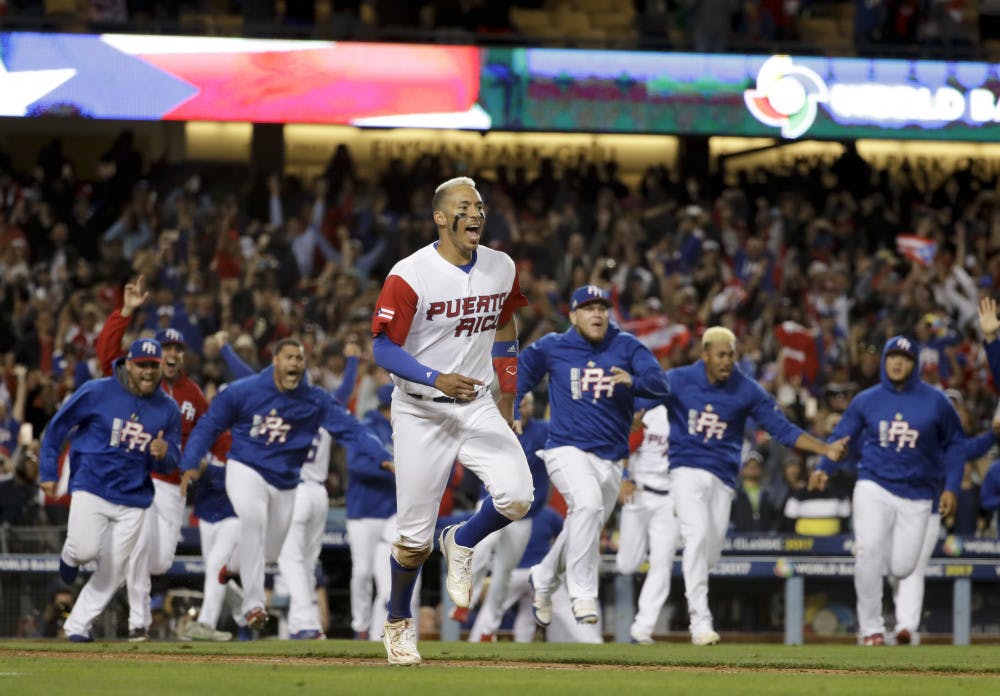 Puerto Rico's Carlos Correa celebrates after scoring in winning run on a hit by Eddie Rosario in the 11th inning of a semifinal against the Netherlands in the World Baseball Classic in Los Angeles, Monday, March 20, 2017. (AP Photo/Chris Carlson)