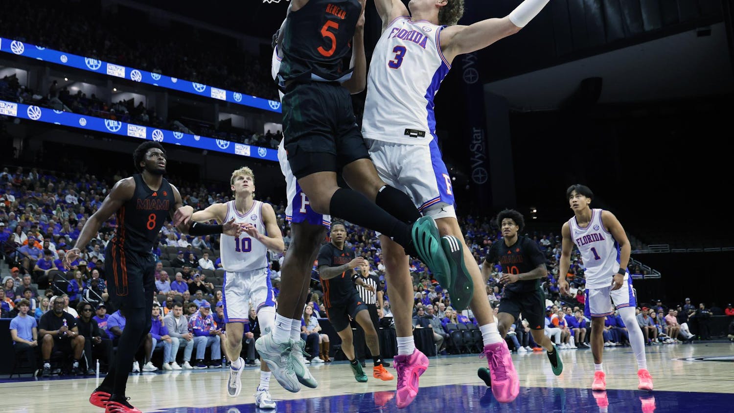 Florida's Micah Handlogten blocks Miami's Malik Reneau from scoring during the Jacksonville Hoops Showdown at VyStar Veterans Memorial Arena in Jacksonville, Fla., on Sunday, Nov. 16, 2025.