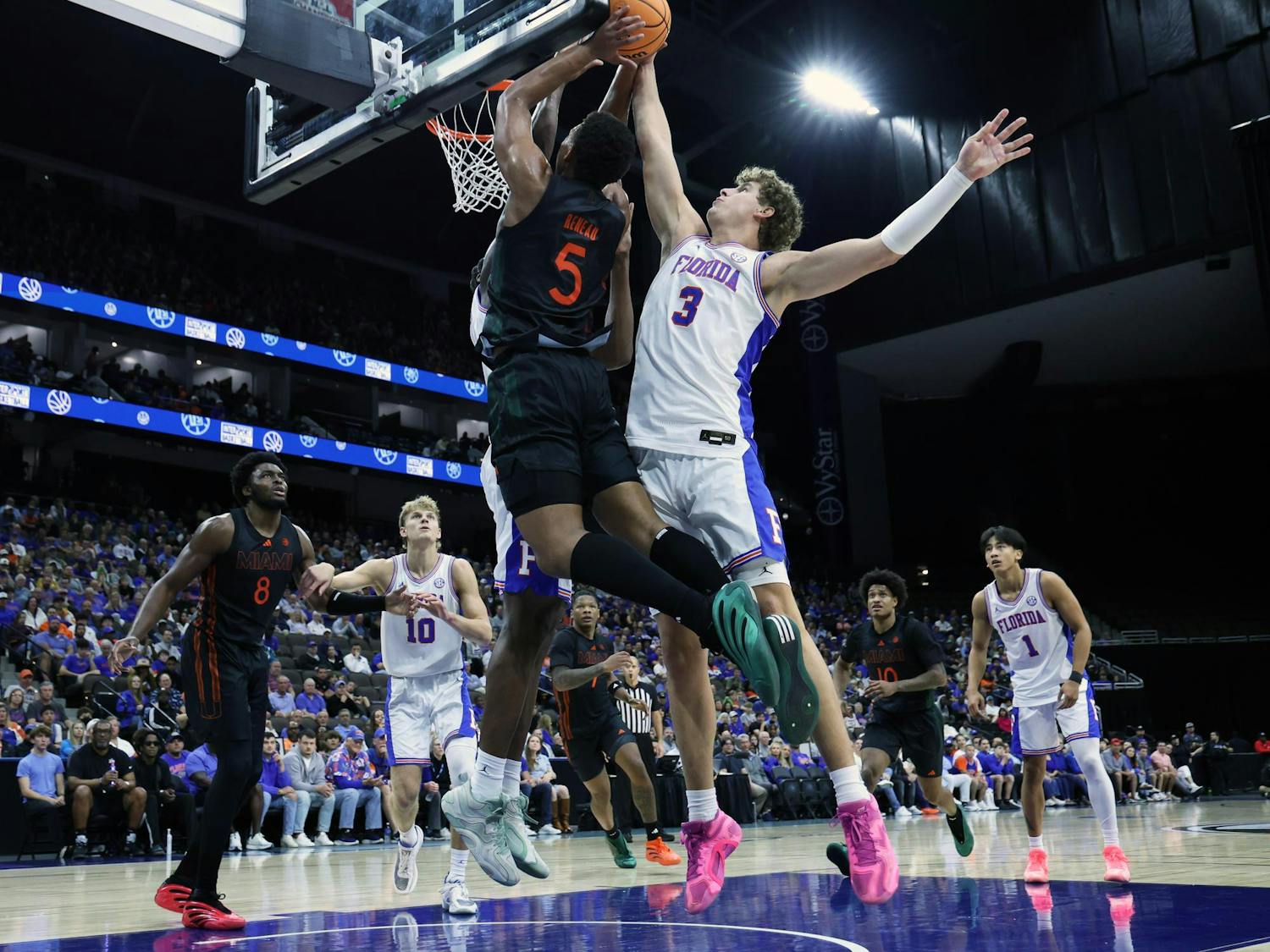 Florida's Micah Handlogten blocks Miami's Malik Reneau from scoring during the Jacksonville Hoops Showdown at VyStar Veterans Memorial Arena in Jacksonville, Fla., on Sunday, Nov. 16, 2025.