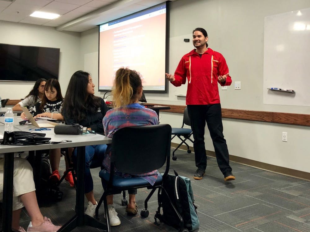 Adam Recvlohe speaks to a group of about 35 people on Indigenous Peoples Day