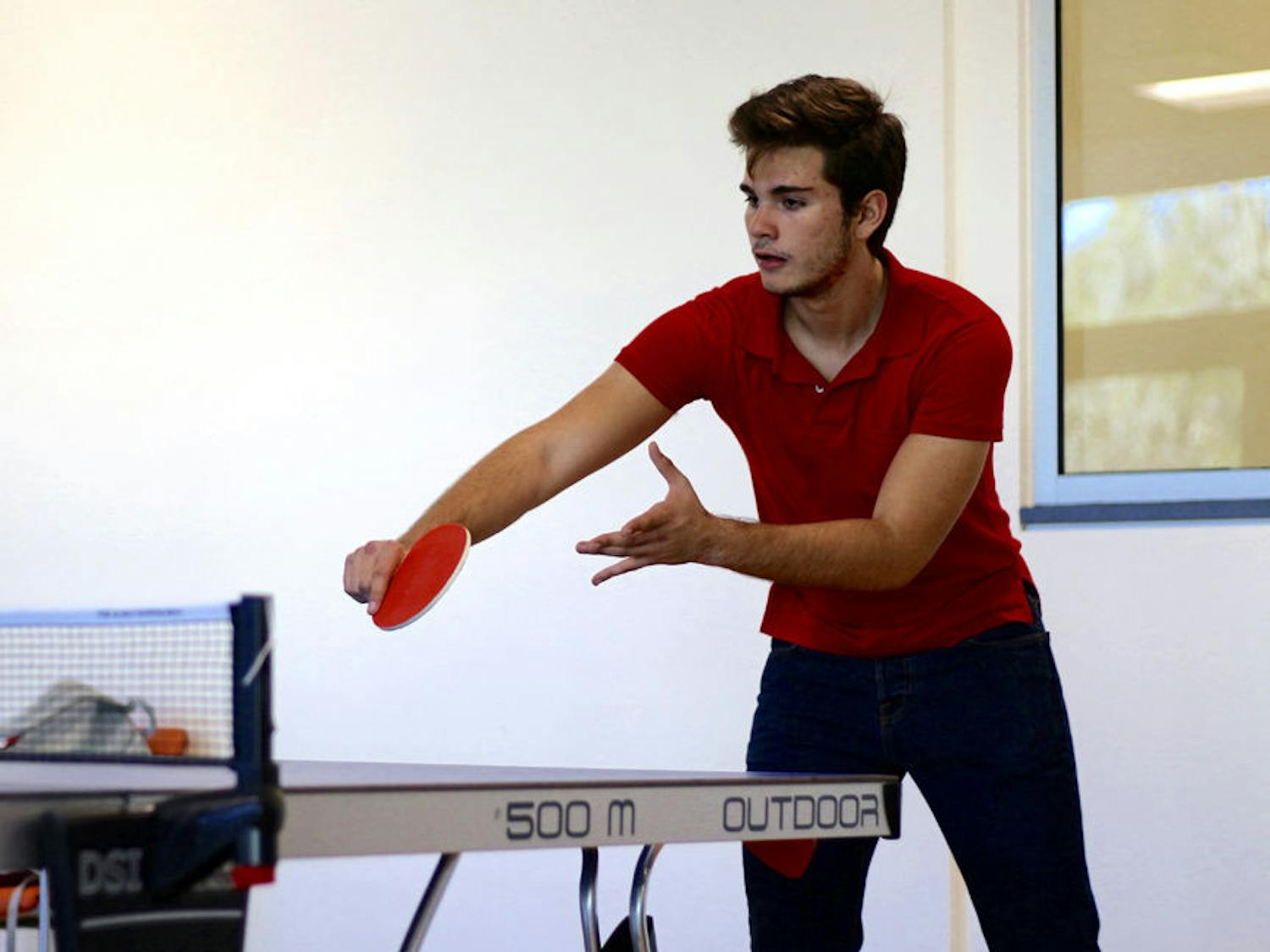 Esteban Siles, an 18-year-old industrial engineering freshman, plays a game of table tennis with his friend Carlos Ancaten in the recently opened Reitz Union Game Room on Tuesday afternoon.