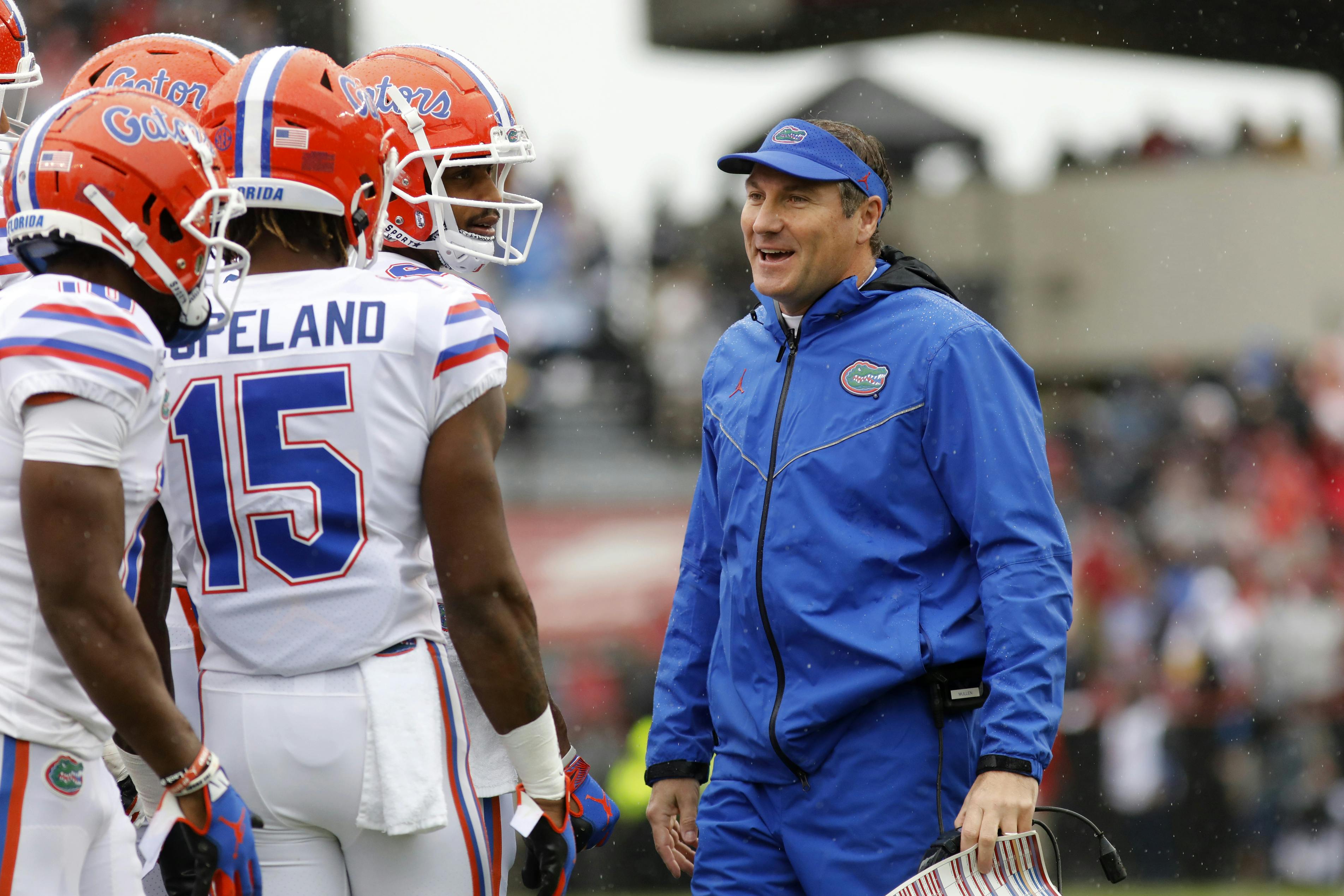 Florida's head coach Dan Mullen smiles with his players during the first half of an NCAA college football game against South Carolina, Saturday, Oct. 19, 2019, in Columbia, SC.